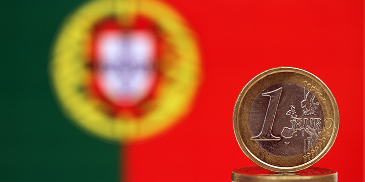 One Euro coin with Portuguese flage in the background One Euro coin with Portuguese flage in the background